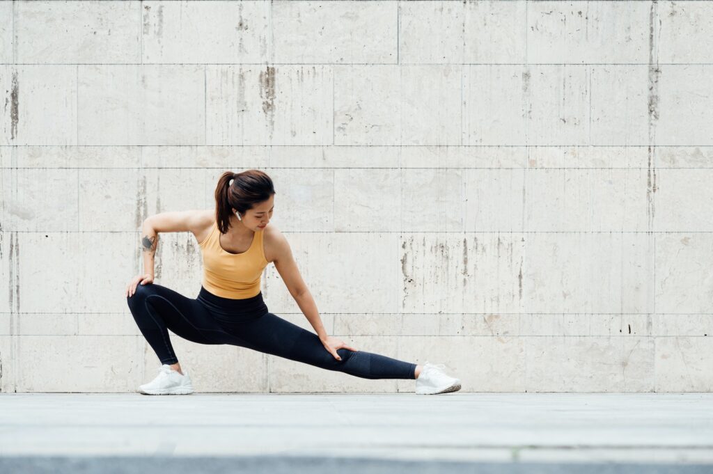 Young Asian woman doing exercise outdoors