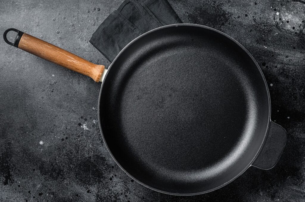 https://scratchmarket.co/wp-content/uploads/2022/12/empty-cast-iron-skillet-for-cooking-on-rustic-towel-black-background-top-view-copy-space-1024x681.jpg