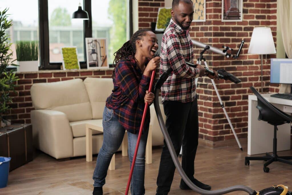 Afro american couple turning spring cleaning into a dance party