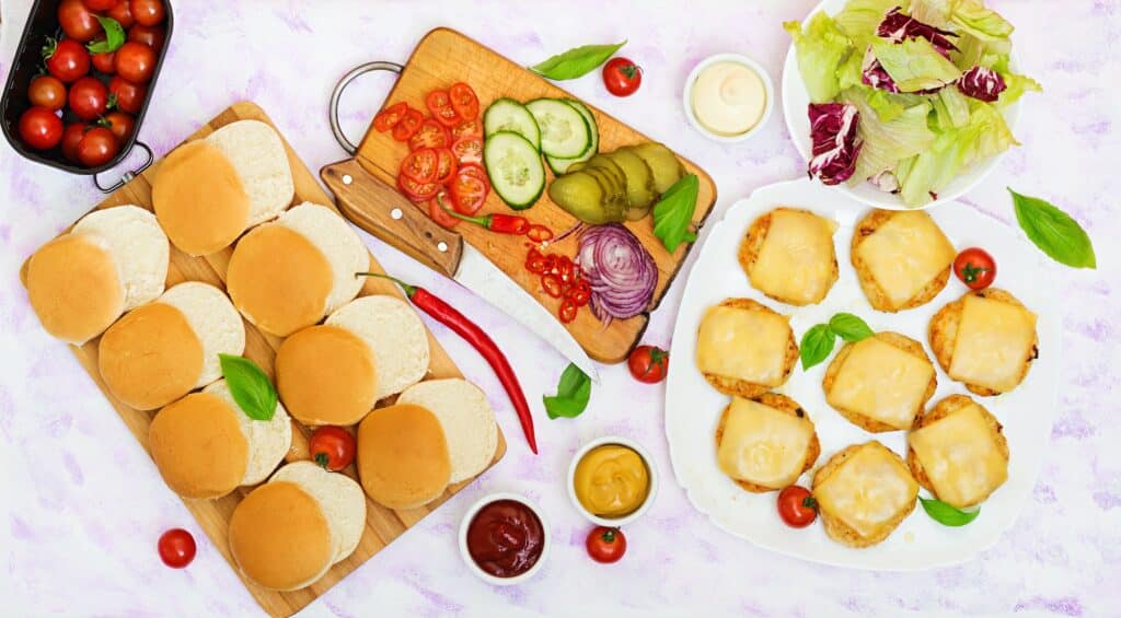 Ingredients for hamburgers with chicken burger, cheese and a vegetables. Flat lay. Top view.