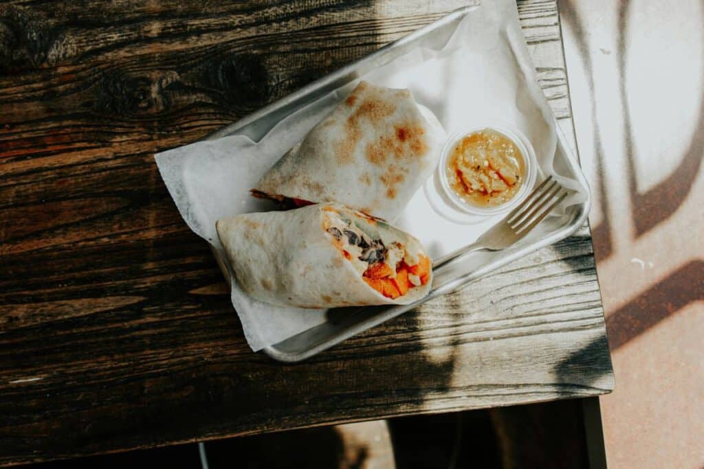 Burrito with sauce on a plate.